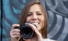 A person smiling and holding a camera.