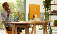 Mac sitting at desk working on yellow Apple iMac 24-inch computer