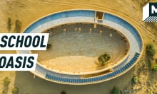 Aerial shot of the oval school amid the desert, solar panels seen on the roof. Caption reads:  school oasis