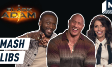 Dwayne Johnson, Sarah Shahi and Aldis Hodge smiling in front of the Black Adam title