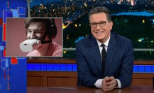 A man sitting behind a talk show desk is seen with another image next to him of a man wearing a gadget over his mouth and winking.