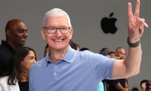 Tim Cook in front of an Apple logo flashing a peace sign