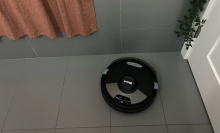 Shark robot vacuum cleaning tile floor near bathtub