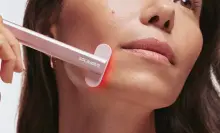 Woman uses a Solawave red light therapy wand