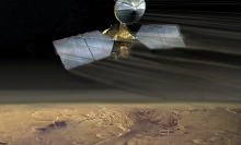 An artist's conception of the Mars Reconnaissance Orbiter swooping over the Martian desert.