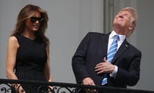 President Donald Trump squinting at the partially eclipsed sun