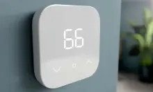 An Amazon Smart Thermostat hangs on a wall.