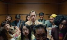 A man standing in a crowded elevator.