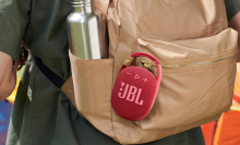 A JBL Clip 4 speaker attached to a backpack