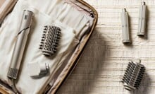 a sharkflex style hair dryer with accessories sits in an open suitcase