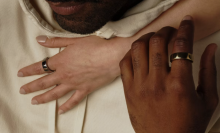 two people's hands with oura smart rings