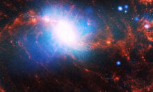 A space photo shows a spiral galaxy with a blue and white centre and orange spirals.