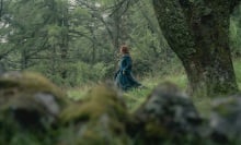 Alicent Hightower walks through the Kingswood in a green dress and cloak.