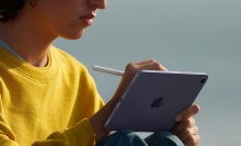 A person holding an iPad Mini with an Apple Pencil