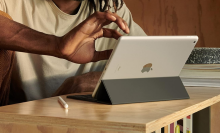 man using apple ipad 9th gen on a desk