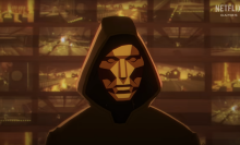 A cartoon image of a hooded man in a mask standing in front of multiple screens.