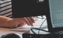 person's hands typing on computer