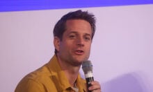 Sebastian Siemiatkowski, CEO of Klarna speaking on a microphone at an event