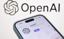 OpenAI logo displayed on a laptop screen and ChatGPT on AppStore displayed on a phone screen