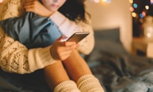 Girl looks at phone in a seated position. 