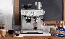 breville barista express surrounded by coffee and accessories