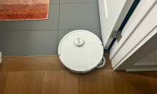 Roborock Qrevo Master robot vacuum cleaning tile and hardwood floor with rug and door in peripherals