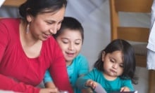 A Native American mom reads to her children.