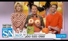 three white people in various holiday sweaters holding two sugar cookies 