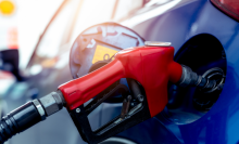 close up of a gas pump filling a blue car 