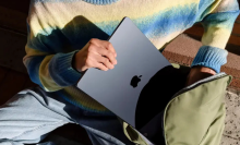 A person putting a MacBook Air into a backpack