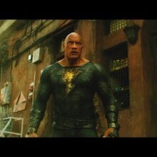 A muscular man in a black superhero suit with a gold lightning bolt on the front.