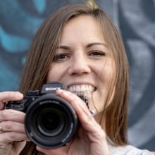 A person smiling and holding a camera.