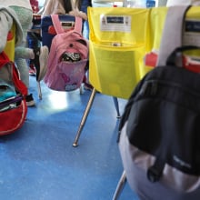 backpacks hanging off desk chairs in a classroom