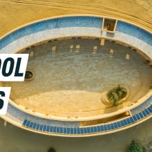 Aerial shot of the oval school amid the desert, solar panels seen on the roof. Caption reads:  school oasis