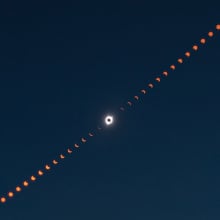 A composite image showing many phases of the eclipse with totality strikingly highlighted in the center