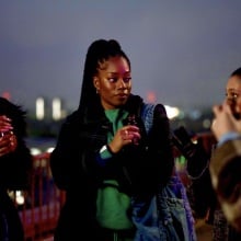 Four young woman at a rooftop party.