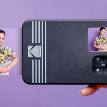 Kodak instant camera taking photo of woman holding flowers