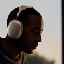 Person sitting at computer and wearing AirPods Max