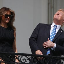 President Donald Trump squinting at the partially eclipsed sun