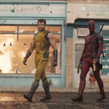 Two superheroes walk side by side on a street.