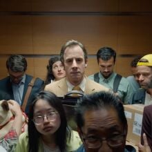 A man standing in a crowded elevator.