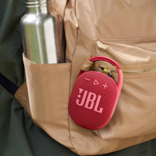 A JBL Clip 4 speaker attached to a backpack