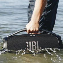 person holding JBL Boombox 3 in ocean