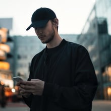 man in hat browsing their phone