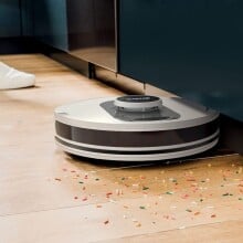 the shark AI ultra robot vacuum picks up colorful sprinkles on a hardwood floor