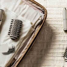 a sharkflex style hair dryer with accessories sits in an open suitcase