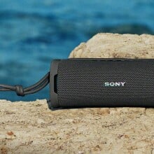 Sony ULT Field 1 speaker sits on a rock near the water