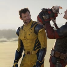 Wolverine watches on in disgust as Deadpool lifts up Dogpool.