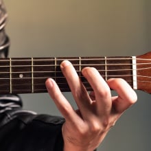 close-up of person playing guitar