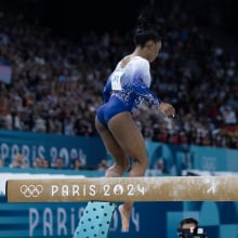 Simone Biles hops down from the balance beam. 